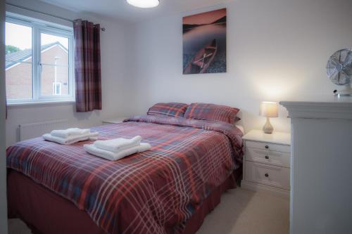 纳伯斯Maes Yr Odyn - 3 Bedroom Holiday Home - Narberth的一间卧室配有一张床,上面有两条毛巾