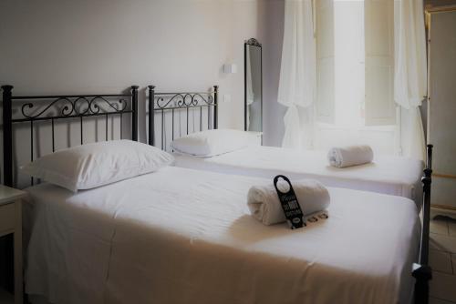 佛罗伦萨Affittacamere ALBA的两张带白色床单和一对毛巾的床