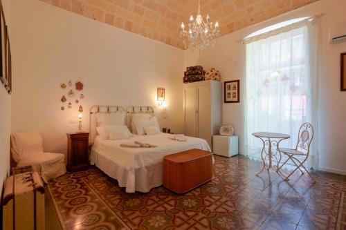 塔兰托B&B Il Melograno Taranto的一间卧室配有一张床、一张桌子和一个吊灯。