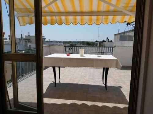马蒂诺La casa di Alex的一张桌子,坐在阳台上,配有雨伞