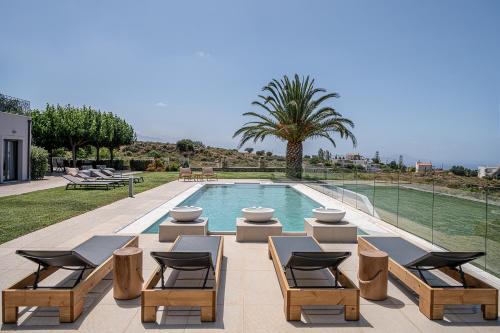 Tria MonastiriaVilla Heora - The Floating Residence的一个带桌椅的游泳池和一个游泳池