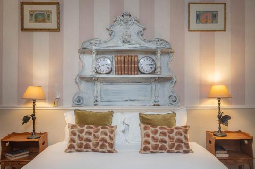 巴黎拉夫尔酒店的一间卧室配有一张床铺,上面有时钟