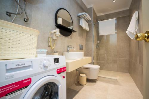 费特希耶Channel Suites的一间带盥洗盆的浴室内的洗衣机