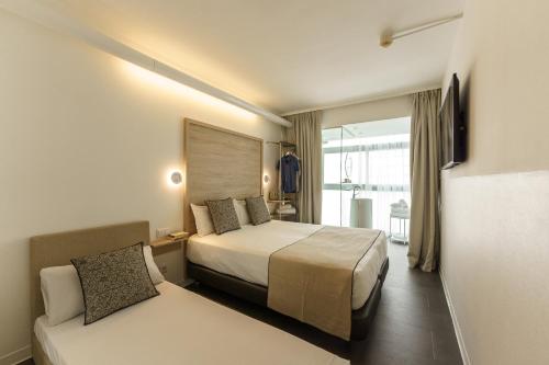 巴塞罗那Casa Lit Barcelona by Ona的酒店客房,配有床和沙发