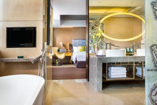 郑州郑州索菲特国际饭店的一间带床、水槽和浴缸的浴室