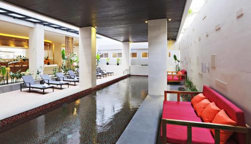 勒吉安尤坲利亚酒店的大堂设有游泳池,配有桌椅