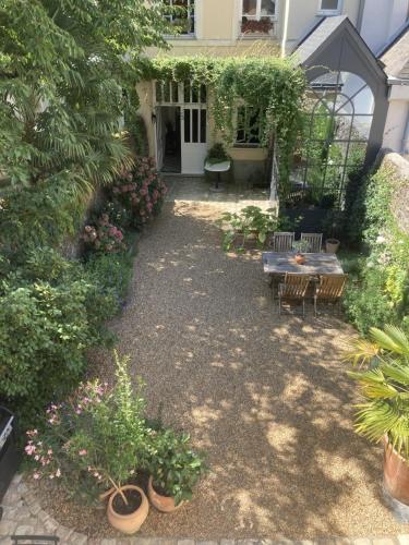 昂热La Maison du Cocher - Chambre indépendante climatisée en Hypercentre - Lit Queen Size的一个带桌子、长椅和植物的花园