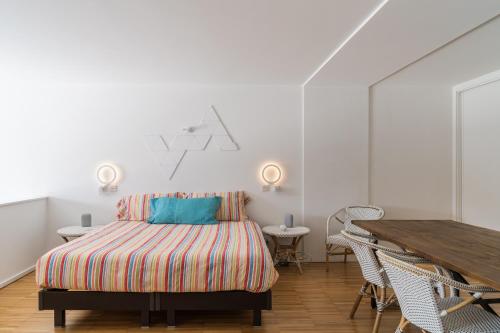 波尔图Porto Insight Apartment River View - Pool & Garage的一间卧室配有一张床和一张木桌