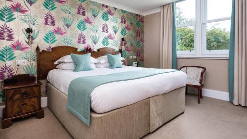 珀斯阳光水岸大厦地铁酒店的一间卧室配有一张带花卉壁纸的大床