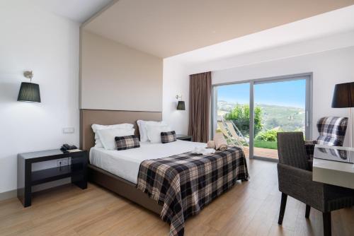 拉梅戈德尔芬杜罗酒店的一间卧室配有一张床、一张书桌和一个窗户。