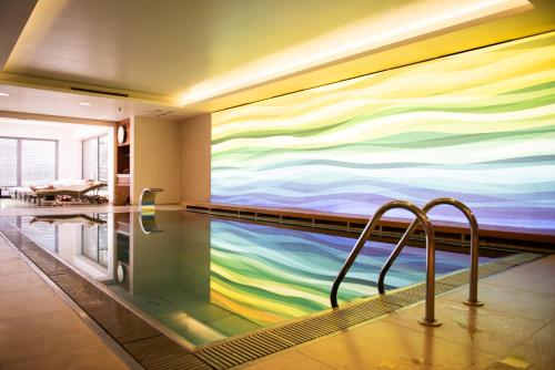 索普隆瓦比酒店 - 美容牙科中心的墙上有彩色壁画的游泳池