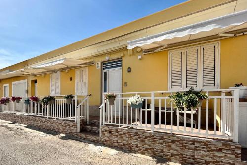 兰佩杜萨Bed and Breakfast Siciliamuri Lampedusa的阳台上种有盆栽植物的黄色房子