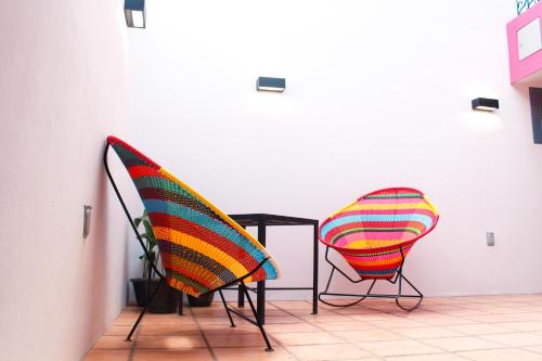 瓦哈卡市Casa Rosa Mexicano的房间里的两张椅子和一张桌子