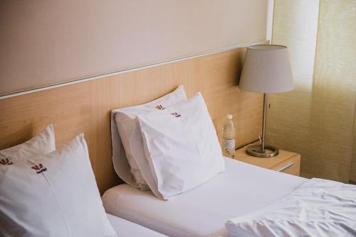 索普隆瓦比酒店 - 美容牙科中心的一张带白色枕头的床和一瓶水