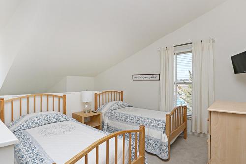 贝瑟尼滩Sea Colony - 55021 Pine Lake的一间卧室设有两张床、一台电视和一扇窗户。