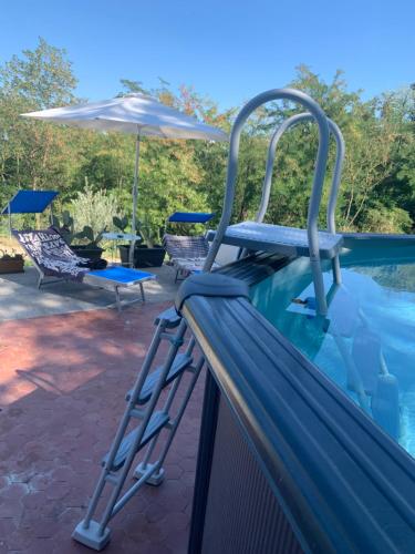 瓦伦扎Ca' degli Ovi的游泳池旁的梯子,带雨伞