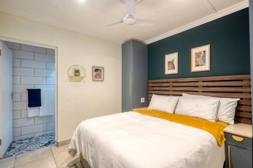 德班Hampton Collection - Trendy 2 Sleeper Apartment with Pool的一间卧室设有一张大床和蓝色的墙壁