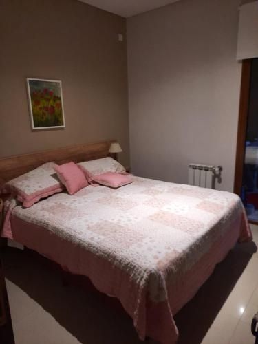 瓦勒里亚德玛Arenas 1的卧室配有一张带粉红色枕头的大床