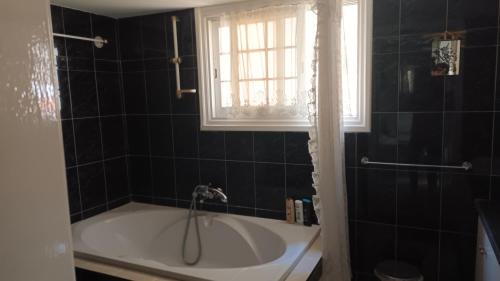 利马索尔绿地乡村俱乐部公寓的带浴缸的浴室和窗户。