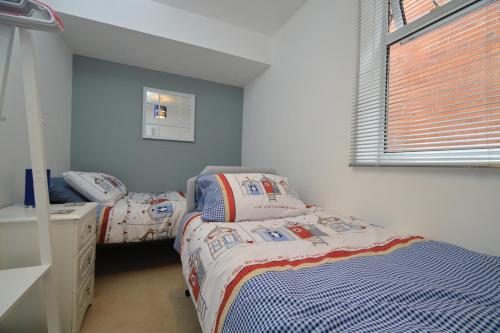 埃克斯茅斯Exmouth - Newly available, near the Beach的一间卧室设有两张单人床和一个窗户。