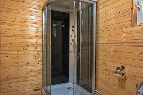 BrebBreb Casa Luca的浴室设有玻璃淋浴间和木墙