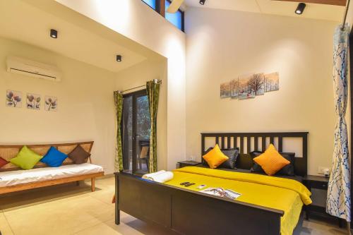 罗纳瓦拉Castle Rock Villa By Tropicana Stays的一间卧室配有黄色的床和长凳