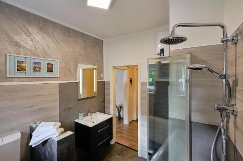 博特罗普Ferienwohnung Mitten im Pott的带淋浴、水槽和玻璃淋浴间的浴室