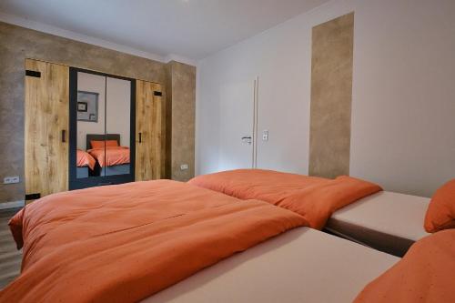 博特罗普Ferienwohnung Mitten im Pott的一间卧室配有一张带橙色毯子的床