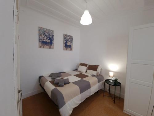 纳扎雷Casa Pisa Flores - Praia da Nazaré的卧室配有一张大床,墙上挂有两张照片