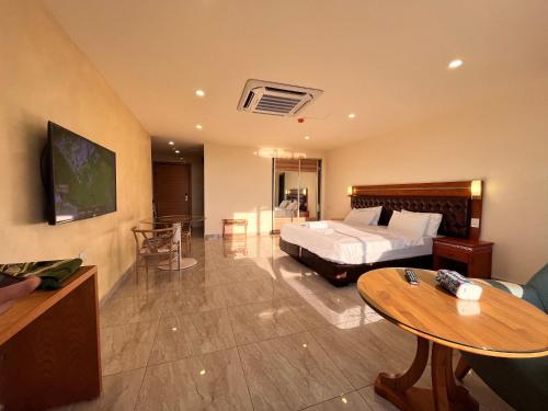 安曼Jawharet Alswefiah Hotel Suites的酒店客房配有一张床铺和一张桌子。