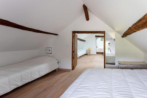 NevoyCABANA & LES PORTES DE LA FORÊT D' ORLÉANS的白色卧室配有床和镜子