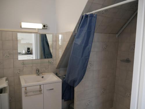 PolignacCHEZ GRAND MAMIE的浴室设有水槽和蓝色的浴帘