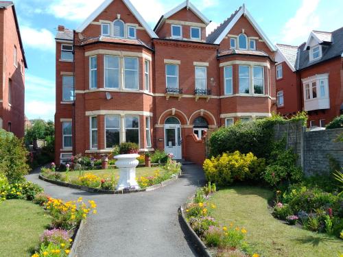 莱瑟姆-圣安妮St Annes Lodge Apartments, Lytham St Annes的一座大型砖屋,前面设有花园