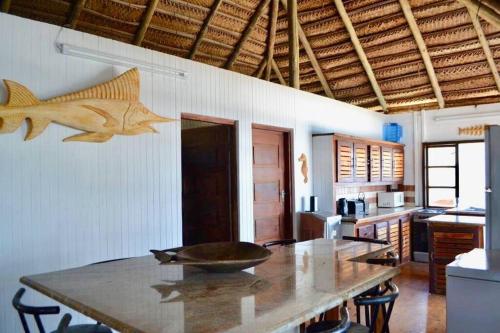 伊尼扬巴内Mozambique,Inhambane,Barra -Entire Beach House的厨房配有桌子,墙上挂着鱼