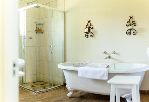 克拉伦斯Baris Guesthouse的带浴缸、淋浴和盥洗盆的浴室