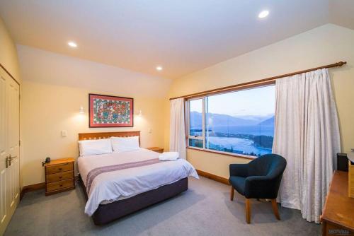 皇后镇Nyumbani - Elevated Lake and Mountain Views的一间卧室设有一张床和一个大窗户
