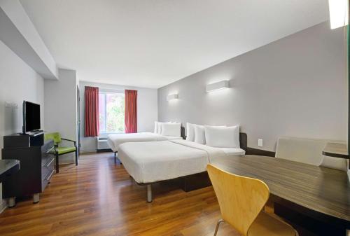 艾尔德里Motel 6 Airdrie的酒店客房设有两张床和一张桌子。
