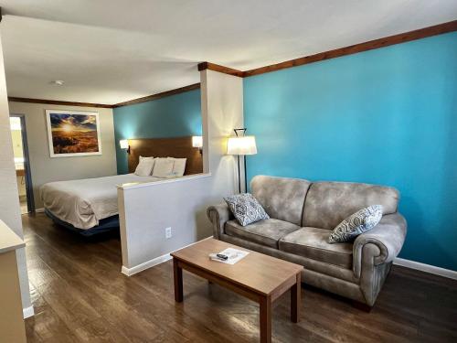 弗雷德里克斯堡Days Inn by Wyndham Suites Fredericksburg的酒店客房设有一张沙发和一张床