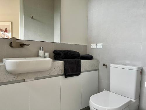 洛恩Architect designed 4 bedroom with ocean views from every room的白色的浴室设有水槽和卫生间。