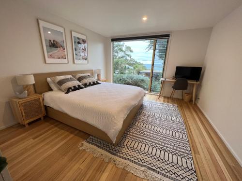 洛恩Architect designed 4 bedroom with ocean views from every room的一间卧室设有一张床和一个大窗户