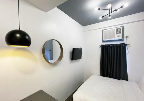 马尼拉mySTAY Hotel BGC East的一间带镜子和床的卧室