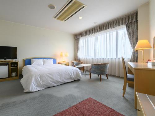 蒲郡市Tabist Katahara Resort Gamagori的酒店客房配有一张床、一张书桌和一间厨房。