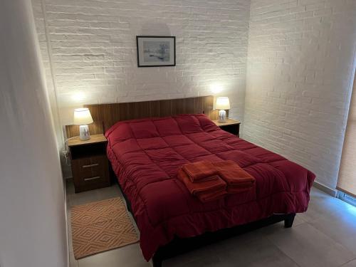 派桑杜Apart del Este 2的一间卧室配有一张红色大床和两盏灯