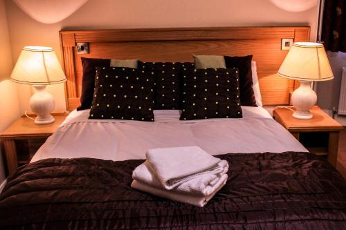 Tinahely墨菲酒店的一张带两盏灯和两条毛巾的床