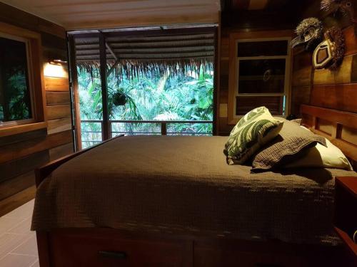 科克莱斯Cabina Harlequin at Margarita Hills Farm的一间卧室设有一张大床和窗户