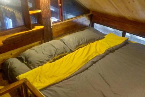 老街市Fieu House的一张床上,床上有黄色的毯子,放在房间里