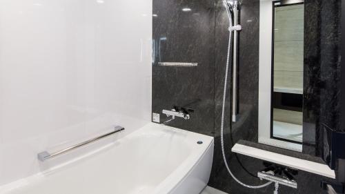 埼玉市Hotel Metropolitan Saitama-Shintoshin的带淋浴、盥洗盆和浴缸的浴室