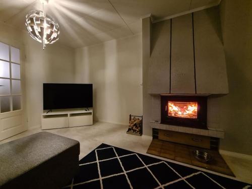 LappersVilla Onia - sauna, palju ja iso yksityinen piha的客厅设有壁炉和电视。