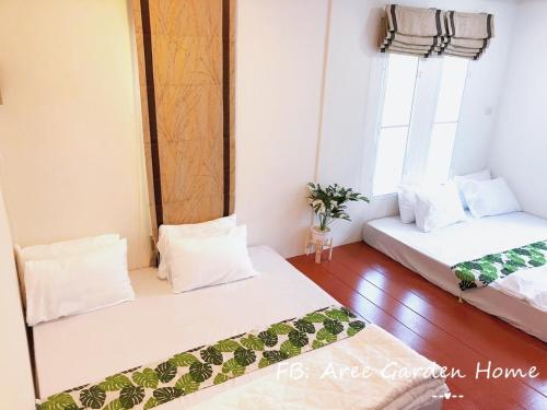 Aree Garden Home Private Homestay by the Waterfall Chantaburi - บ้านสวนพลิ้วอารี ริมธารน้ำตกพลิ้ว จันทบุรี的带2扇窗户的客房内的2张床