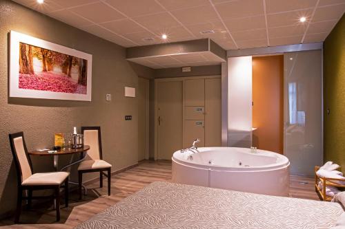 奥维多阿贝多乐斯汽车旅馆的带浴缸和桌椅的大型浴室